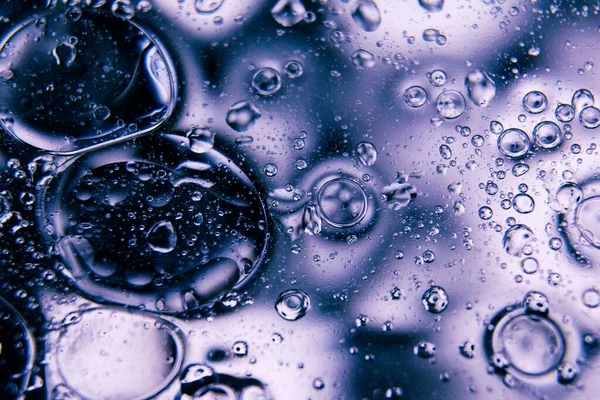 Eine Makroaufnahme Von Wassertropfen Auf Einem Glas Mit Violettem Hintergrund — Stockfoto