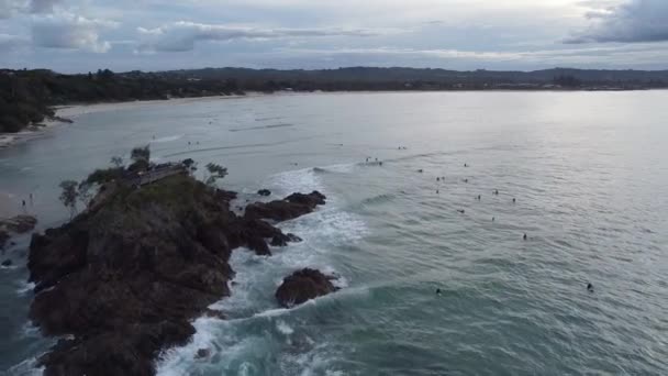 在澳大利亚新南威尔士州拜伦湾 一个与冲浪选手一起在海里冲浪的渔民偷窥的无人驾驶镜头 — 图库视频影像