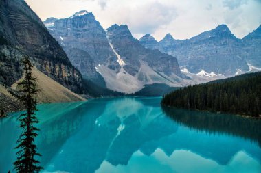 Dağlık arka planda şeffaf bir nehrin manzarası.