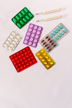 Çeşitli tıbbi ekipmanlar, termometre, ampuller, boru, uyuşturucu, tabletler, kapsüller, sprey, yama, şırınga, beyaz arka planda şişeler. İlaç.,