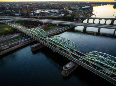 Trenton City, New Jersey 'de gün doğumunda nehrin üzerindeki asma köprülerin insansız hava aracı görüntüsü.