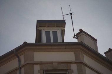 Güneşli bir günde mavi gökyüzüne bakan bir tavan arası penceresinin alçak açılı görüntüsü.