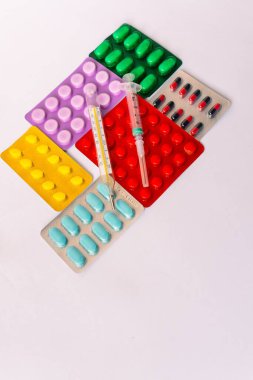 Çeşitli tıbbi ekipmanlar, termometre, ampuller, boru, uyuşturucu, tabletler, kapsüller, sprey, yama, şırınga, beyaz arka planda şişeler. İlaç.,