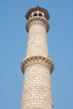 Mavi gökyüzüne karşı Taj Mahal kulesinin dikey görüntüsü.