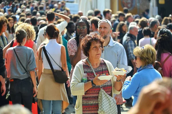 一个女人在拥挤的地区散步 手里拿着意大利街头食物 — 图库照片