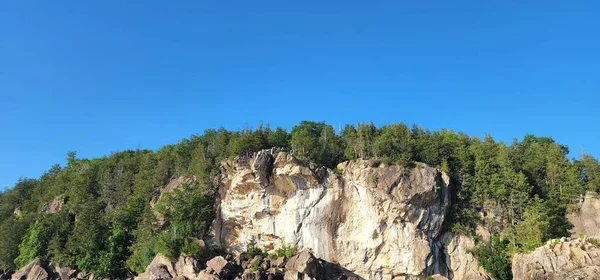 蓝色天空下的岩石山的低角图像 — 图库照片