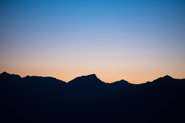 A silhouette of mountain rage with sunset in the background in Vorarlberg, Austria