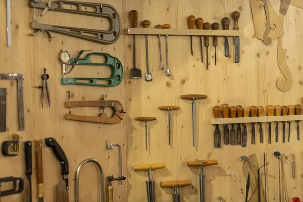 stock image A set of different tools hanging on a wooden wall in a workshop