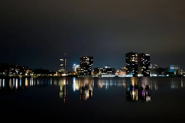 城市新现代建筑的水平截图及其在夜晚湖中的倒影 — 图库照片