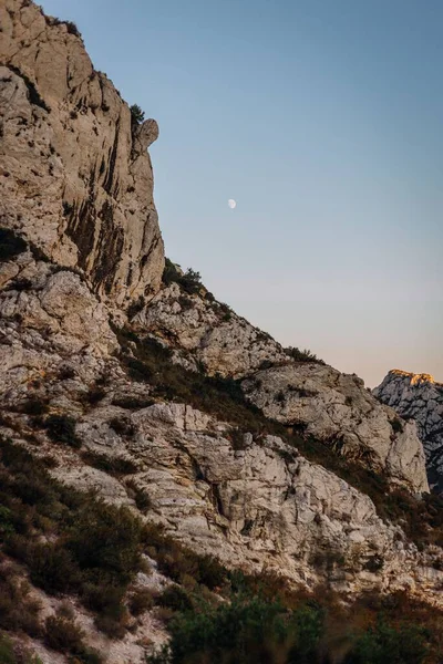 stock image A vertical view of the Massif des Calanques with the moon in the blue sky in the background