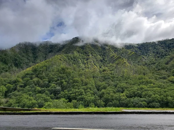 stock image A beautiful shot of a river surrounded by green forested hills on a cloudy day