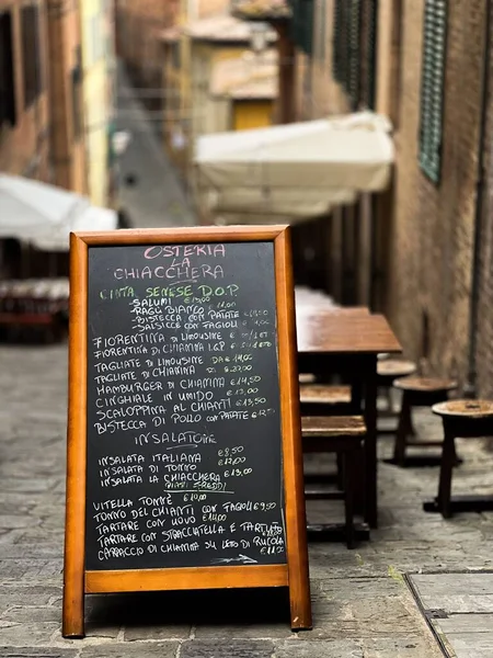イタリアの狭い通りにある黒い板の上に提示されたカフェメニューの垂直閉鎖 — ストック写真