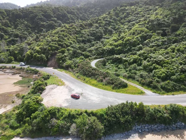 Widok Krajobrazu Czerwonego Samochodu Wąskiej Drodze Zielonych Bujnych Drzew Tle — Zdjęcie stockowe