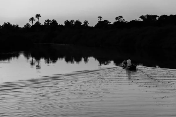 午後遅く アラトゥイペ市のジャガリペ川でカヌーを漕いでいる漁師の白黒写真 — ストック写真