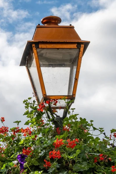 Egy Függőleges Közelkép Egy Utcai Lámpáról Virágok Tetején — Stock Fotó