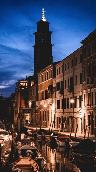 イタリアのヴェネツィアで夜に運河近くの照明建物の垂直ショット — ストック写真