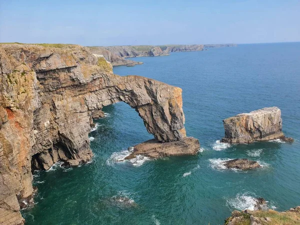 stock image A top view of the natural arch, rugged limestone of Green Bridge of Wales surrounded by a scenic sea