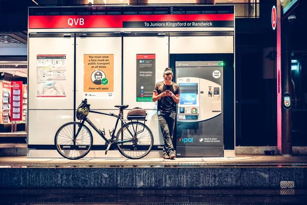 Άνθρωπος Περιμένει Στο Σταθμό Του Τραμ Ενώ Χρησιμοποιεί Τηλέφωνο Μια — Φωτογραφία Αρχείου