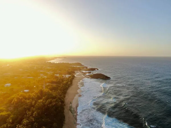 大きな岩や波でビーチの上に黄金の夕日の空中ビュー — ストック写真
