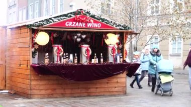 Noel süslemeleriyle süslenmiş küçük bir Noel pazarında şarap satılıyor.