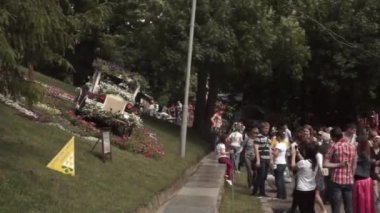 Birçok insan Ukrayna 'daki Kiev parkında çiçeklerle süslenmiş arabayı ayakta ve fotoğraflıyor.