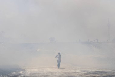 Söndürülen bir yangından çıkan bir insan.