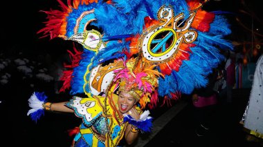 A woman dancing in a traditional costume during a Junkanoo parade in the Bahamas. clipart