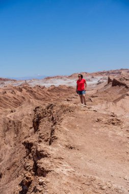 Şili 'deki Atacama Çölü' nde mavi gökyüzünün altında İspanyol bir kadının dikey çekimi.