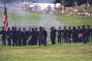 Jackson City, Michigan, ABD 'deki iç savaş canlandırmasını izleyen seyirciler arasında askeri bir performans.