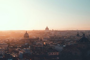 Bir şehrin yüksek açılı görüntüsü Roma 'nın güneş ışığı ve mavi gökyüzü.