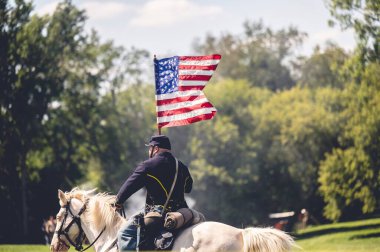 Amerikan İç Savaşı 'nın Jackson City, Michigan' daki canlandırmasında Amerikan bayrağını taşıyan bir asker.