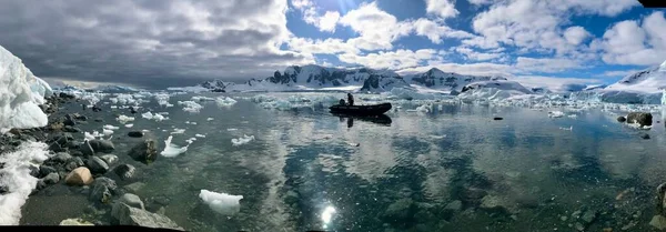 南极洲的一个反光湖 湖中有一艘船 周围是雪山 天空明亮多云 — 图库照片