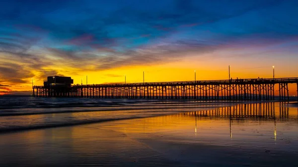 夕方の黄金の夕日の前に海の上の桟橋の遠いショット — ストック写真