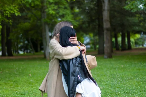 在一个与世隔绝的背景下 两个女性朋友在公园拥抱的特写镜头 — 图库照片