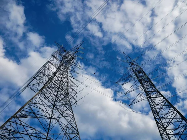 Bulutlu Mavi Gökyüzüne Karşı Düşük Açılı Elektrik Kuleleri Görüntüsü — Stok fotoğraf