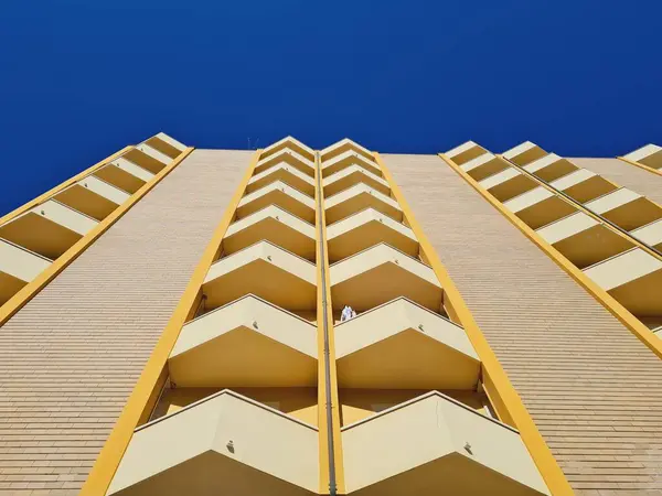 stock image A low angle shot of a geometrically shaped building with balconies on a sunny day