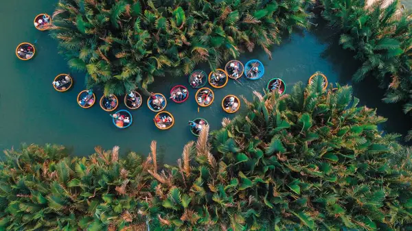 熱帯の木々に囲まれたベトナムで丸いバスケットボートを楽しむ観光客の鳥の目のビュー — ストック写真