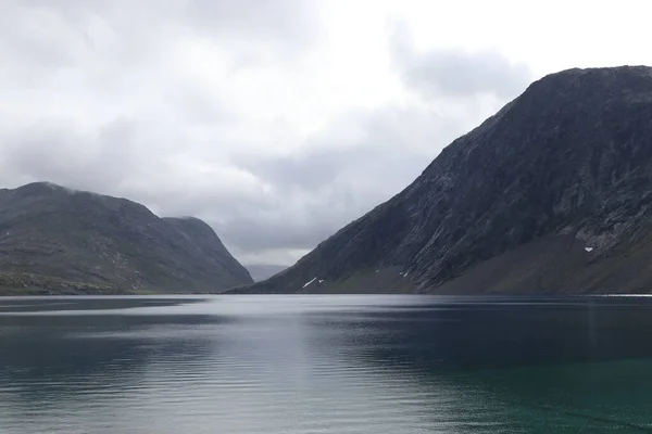 ノルウェーのゲイルアンゲルフィヨルドの美しい景色と 曇った灰色の空の下で水の周りの緑の丘 — ストック写真