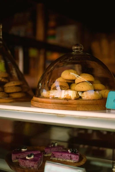 ビスケットとチーズケーキが並ぶカフェショーケースの垂直ショット — ストック写真