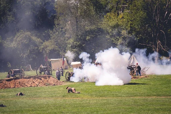 A big smoke and soldiers around in a military camp in the Civil War Muster reenactment of Jackson city, Michigan, USA