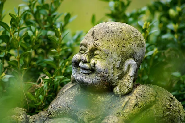 Eine Nahaufnahme Einer Lächelnden Buddha Statue Mit Grünen Pflanzen Hintergrund — Stockfoto