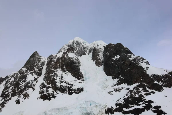 Χαμηλή Οπτική Γωνία Ενός Ψηλού Βραχώδους Βουνού Καλυμμένου Χιόνι Κάτω — Φωτογραφία Αρχείου