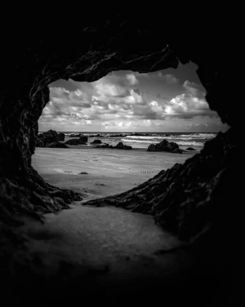 Вертикальный Снимок Моря Пляжа Оттенках Серого Изнутри Пещеры — стоковое фото