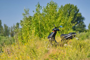 Bir tarlaya park etmiş bir scooter 'ın yakın plan çekimi.
