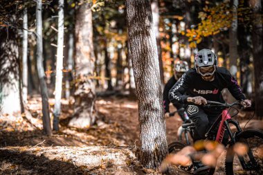 İki binicinin Holeshotpunx 'tan gelen gıcır gıcır mallarla yerel yolları parçaladığı yatay bir çekim.