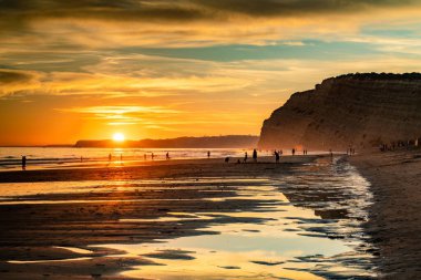 Sahilde renkli bir gün batımı manzarası.