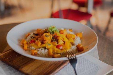 Beyaz bir tabakta servis edilen Sweet Potato Curry 'nin yakın çekimi - restoran yemeği konsepti