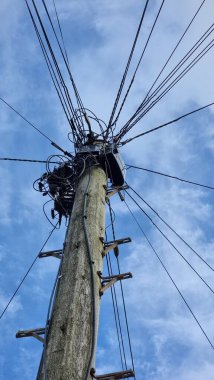 Bir telefon direğinin düşük açılı görüntüsü, İngiltere kırsalındaki eski bir telefon hattı.