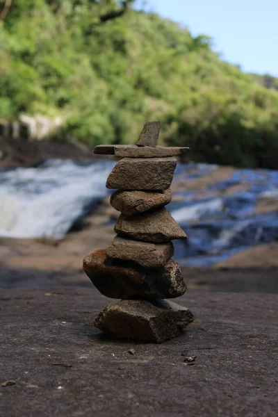 森林中河岸上一块平衡的岩石的垂直拍 — 图库照片