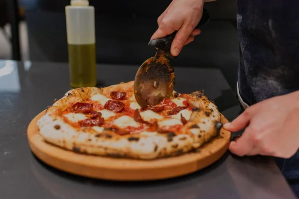 Ένα Top Closeup Του Ένα Χέρι Κοπής Πρόσφατα Ψημένο Πίτσα — Φωτογραφία Αρχείου